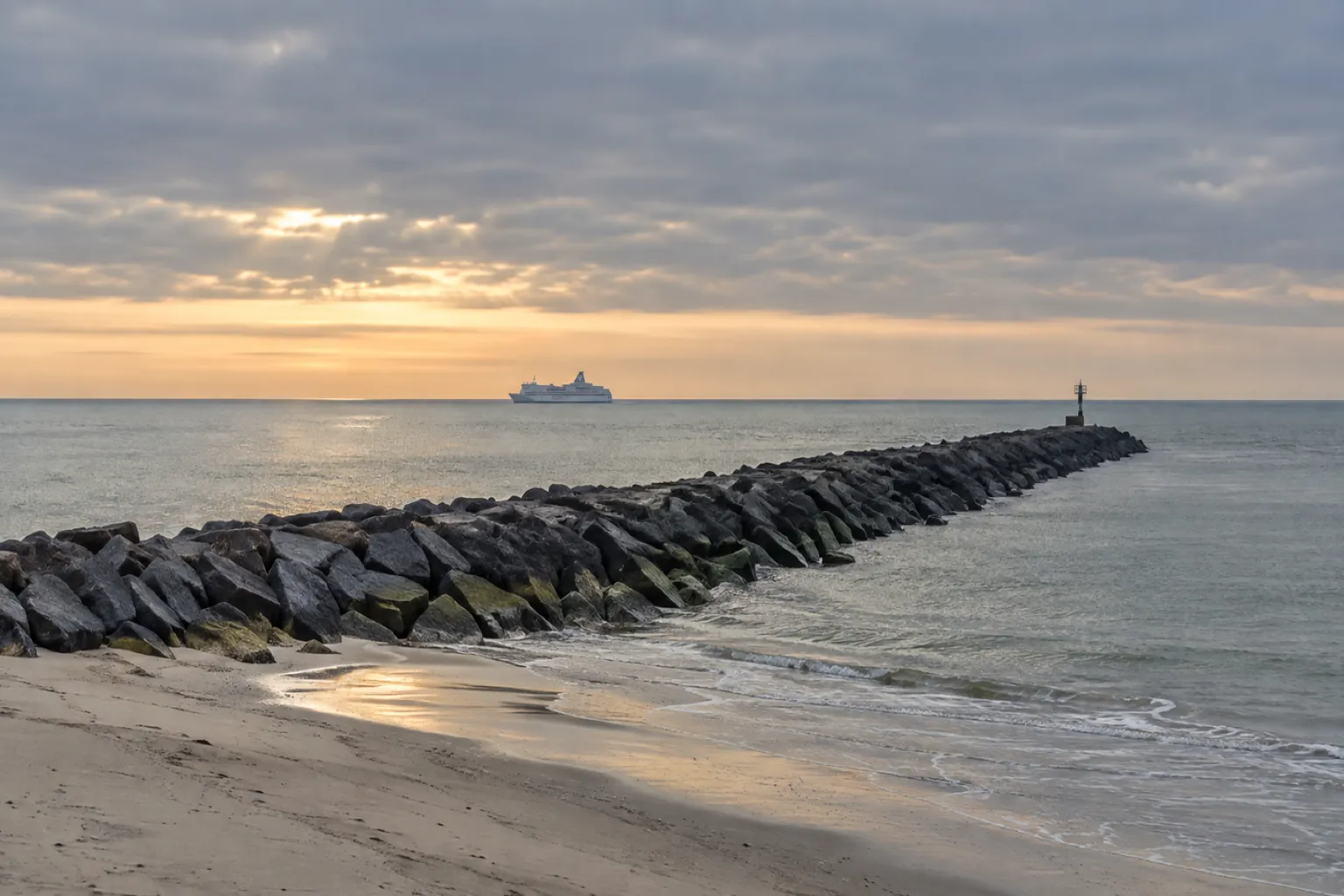 The North Sea coast at Hook of Holland at dawn, a ferry on the horizon heading for England